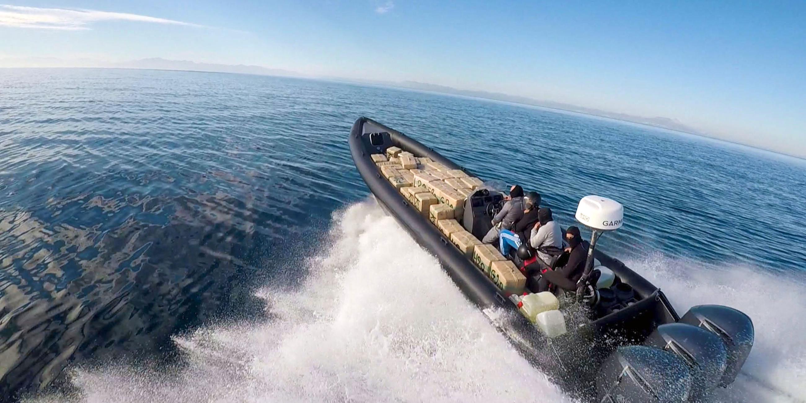 "Europas Drogentor - Spanien im Kampf gegen Schmuggler": Vier vermummte Personen auf einem kleinen Schnellboot voller Drogenpakete auf dem Meer.