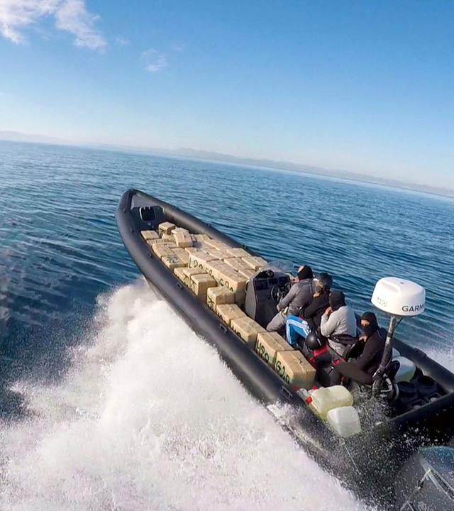 "Europas Drogentor - Spanien im Kampf gegen Schmuggler": Vier vermummte Personen auf einem kleinen Schnellboot voller Drogenpakete auf dem Meer.
