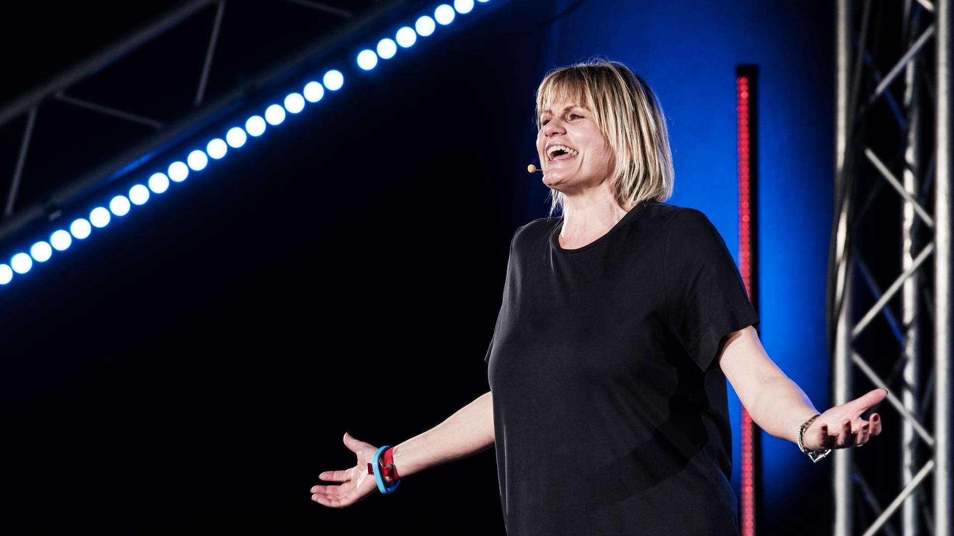 Eine Frau in schwarzem T-Shirt auf einer Bühne