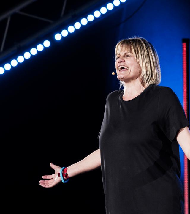 Eine Frau in schwarzem T-Shirt auf einer Bühne