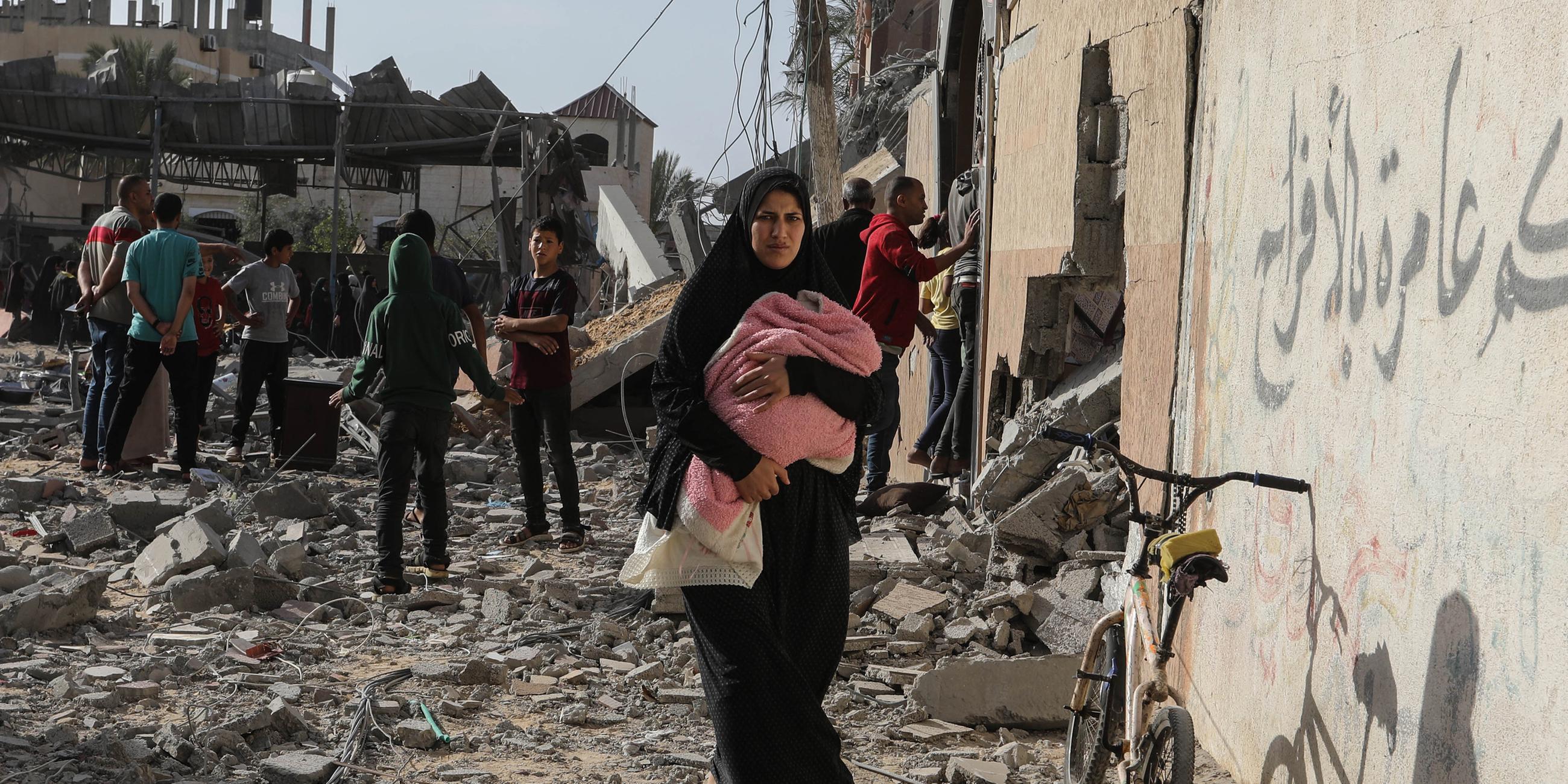 Palästinenser inspizieren beschädigte Häuser, nachdem israelische Kampfflugzeuge ein Haus bombardiert hatten.