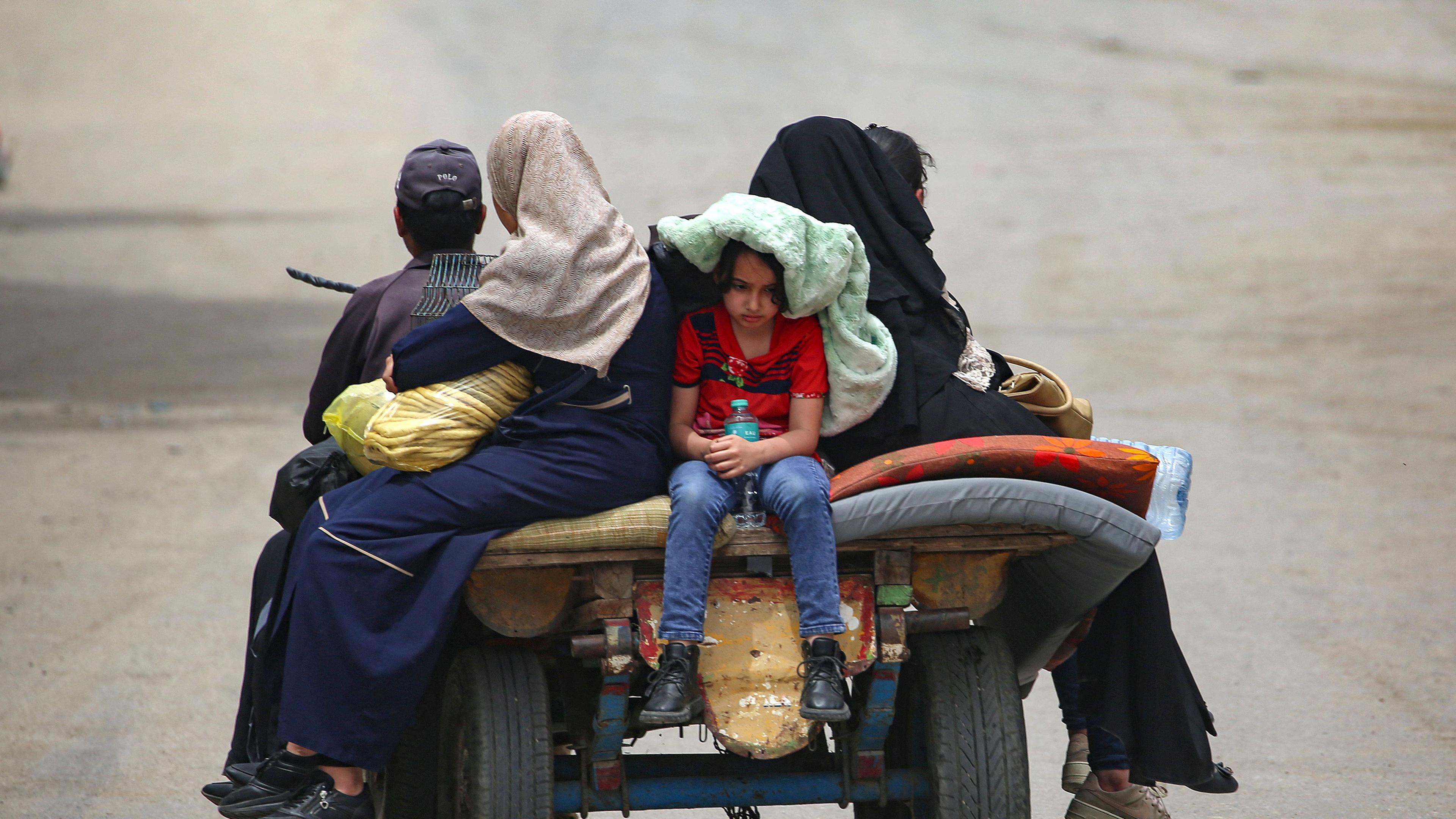 Mehrere Palästinenser sitzen auf einem Wagen während sie Rafah verlassen.