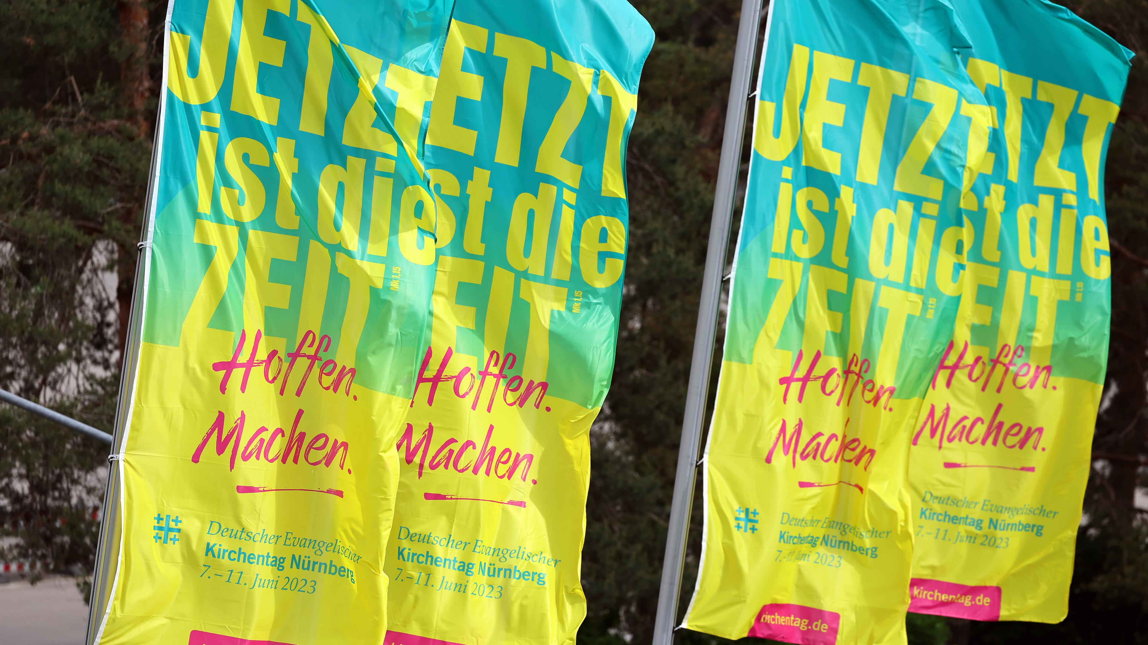 Bayern, Nürnberg: Fahnen mit der Aufschrift «Jetzt ist die Zeit - Hoffen. Machen.» wehen vor dem Messezentrum.