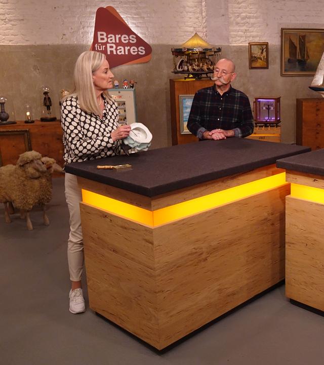 Expertin Dr. Friederike Werner (links) hat ein Objekt zur Begutachtung in der Hand. Sie und Horst Lichter (Mitte) schauen das Verkäuferpaar (rechts) an.