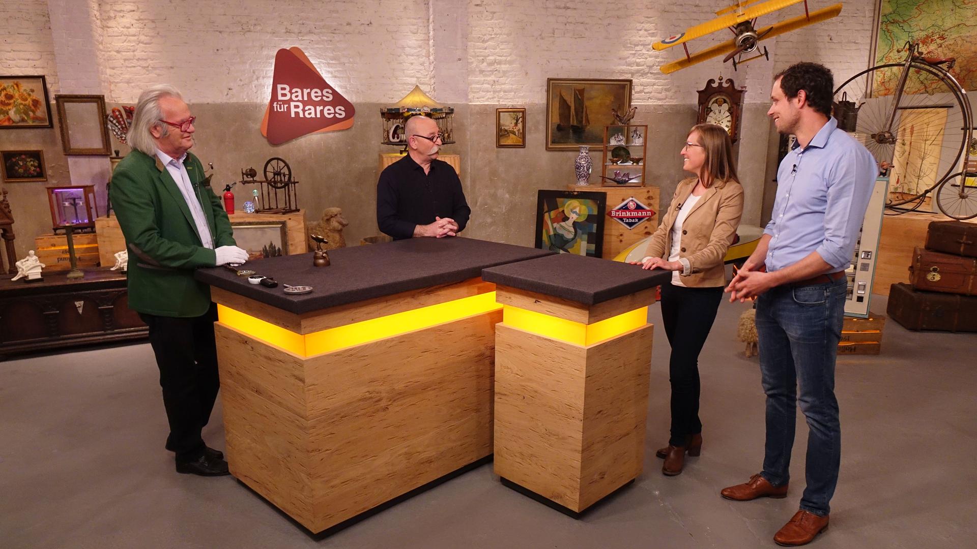 Im Expertisenraum stehen am Expertisentisch Albert Meyer, Horst Lichter und ein junges Verkäuferpaar.