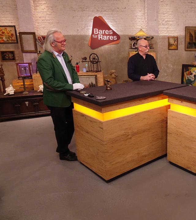 Im Expertisenraum stehen am Expertisentisch Albert Meyer, Horst Lichter und ein junges Verkäuferpaar.