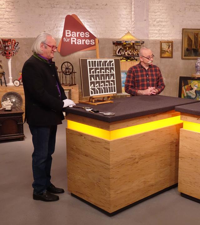 Expertise von Albert Maier. Horst Lichter und ein älteres Verkäuferpaar stehen ebenfalls am Expertisentisch.