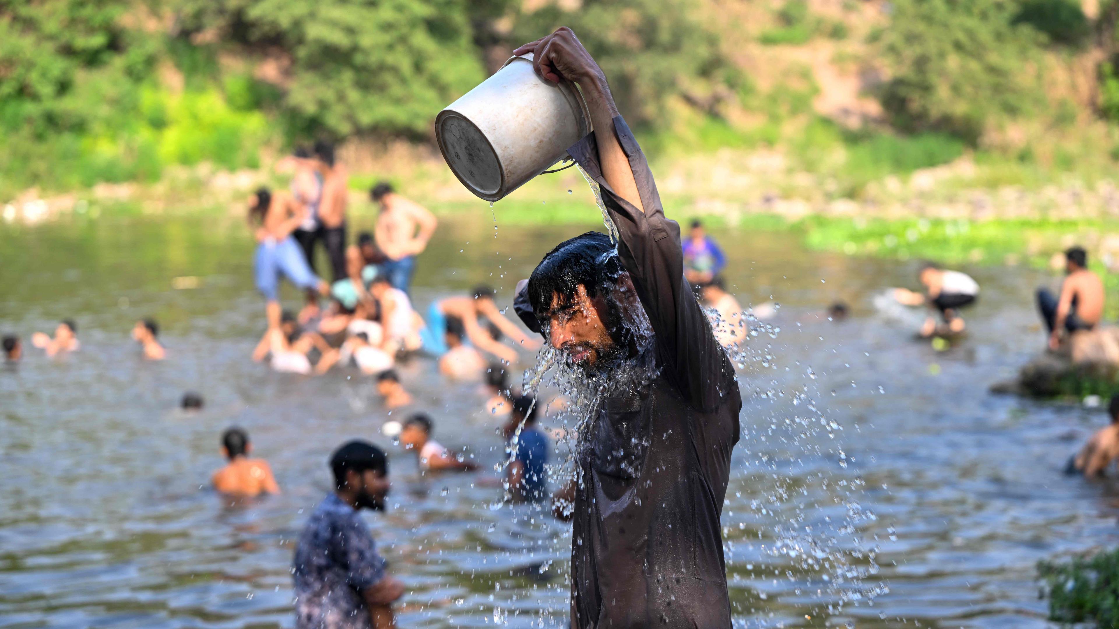 An einem heißen Sommertag in Islamabad am 23. Mai 2024 baden Menschen im Wasser des Rawal-Staudamms.
