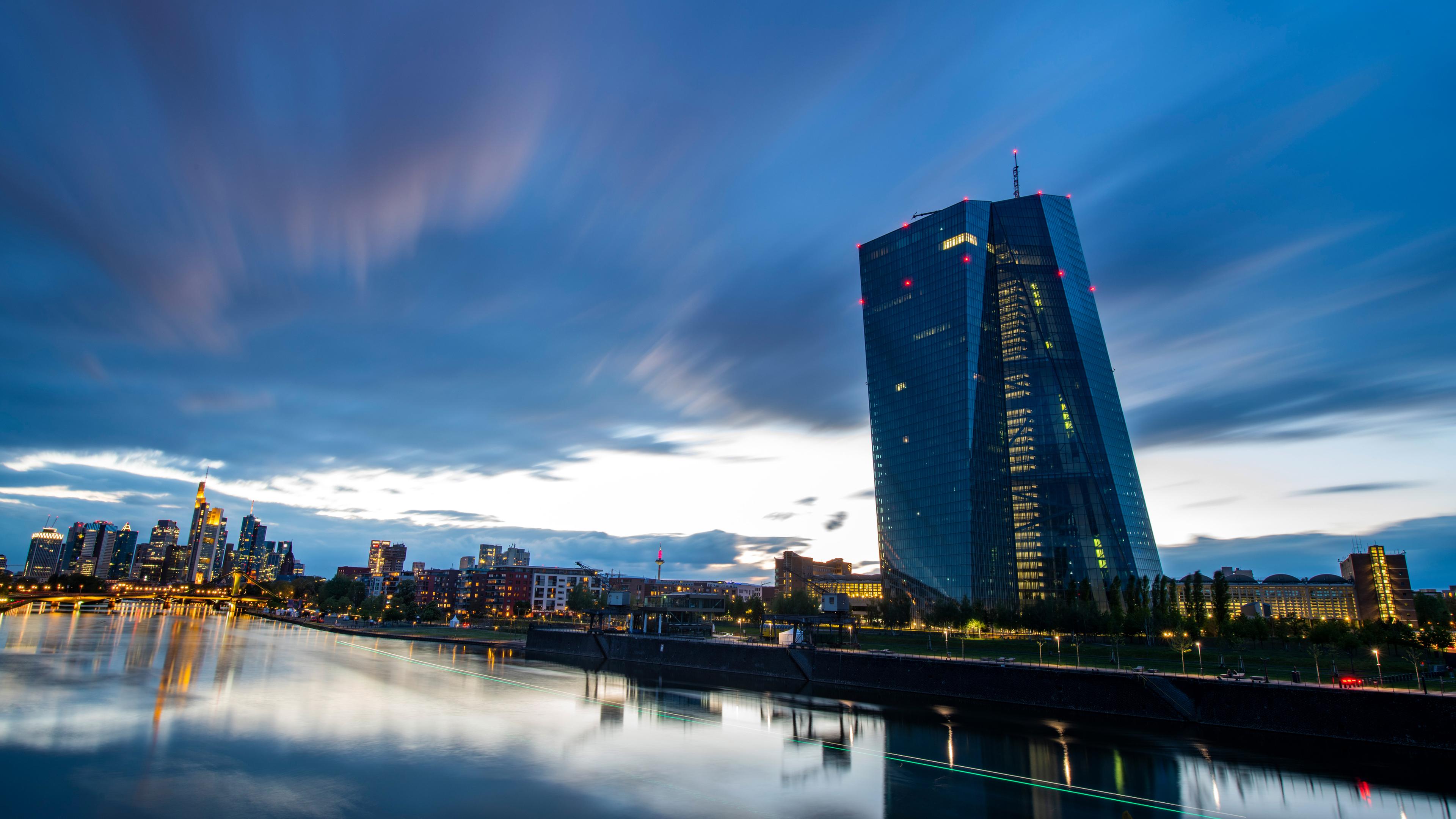 Hessen, Frankfurt/Main: Der Wind treibt kurz nach Sonnenuntergang dunkle Wolken über die abendliche Bankenskyline und die Europäische Zentralbank (EZB) in Frankfurt am Main.