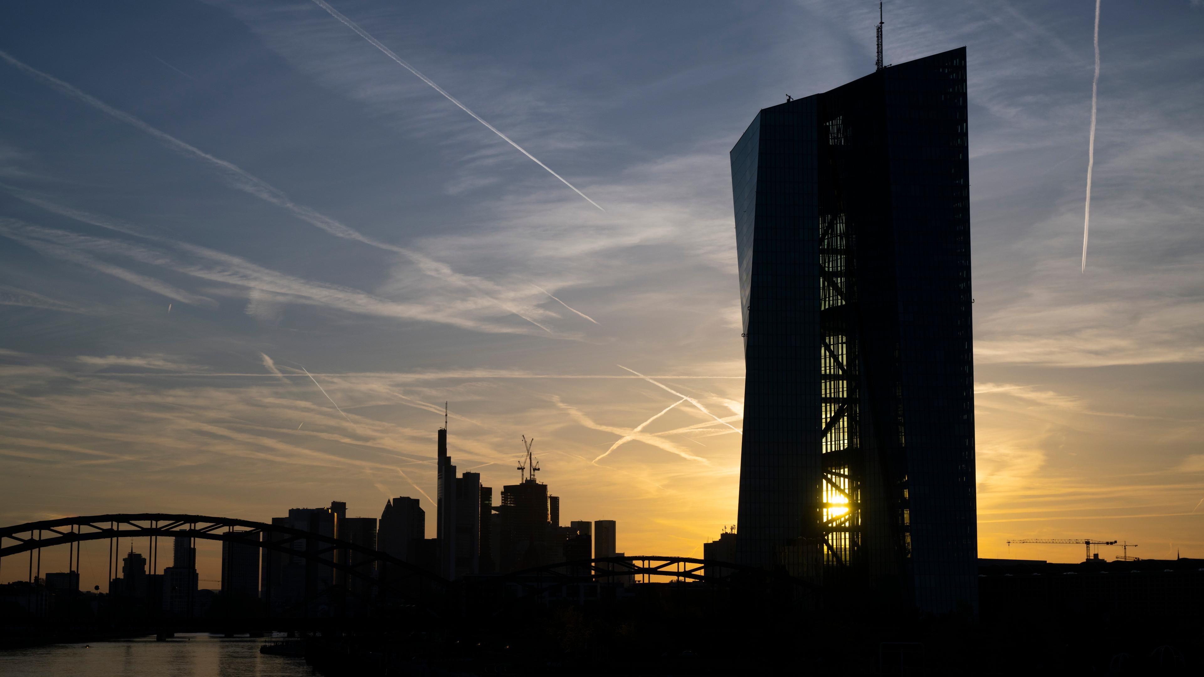 Die Sonne geht hinter der EZB in Frankfurt unter. 