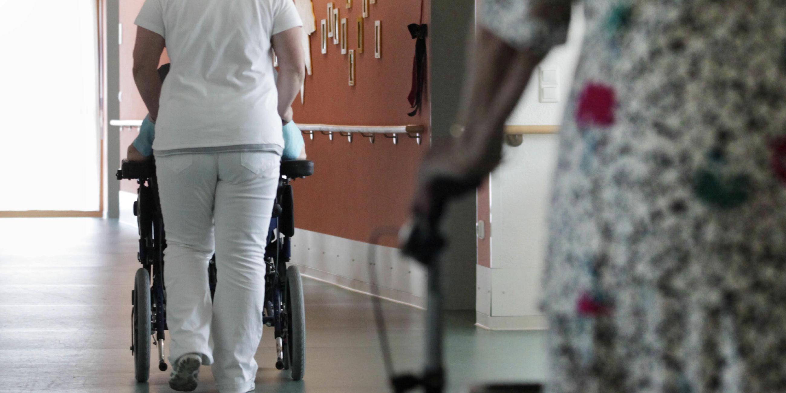 Pflegerin schiebt einen Rollstuhl