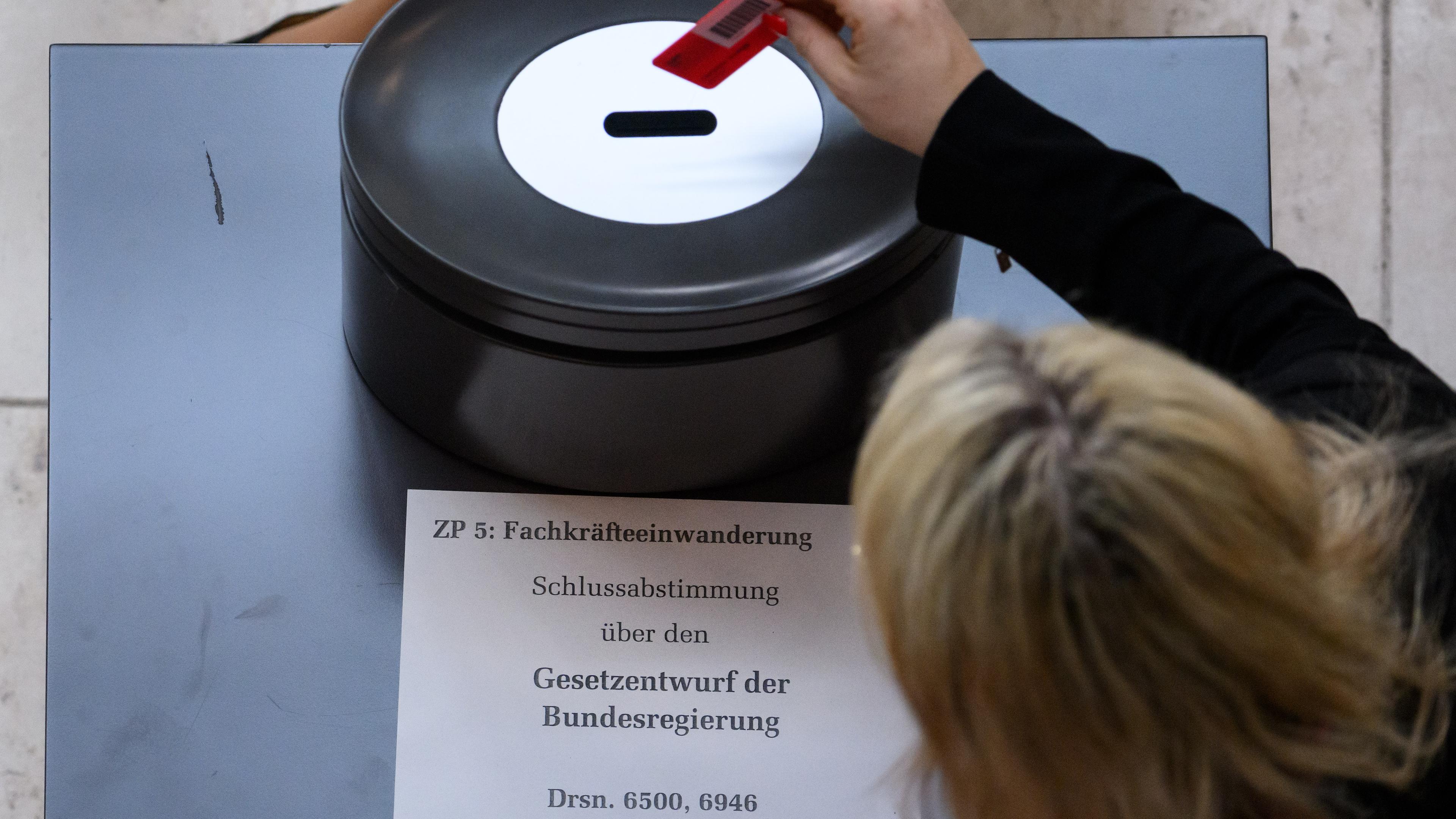 Bundestagsabgeordnete geben bei der Abstimmung über den Gesetzentwurf zur Fachkräfteeinwanderung im Deutschen Bundestag ihr Stimmkarte ab.