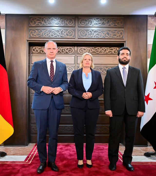 Gerhard Karner, Bundesminister für Inneres der Republik Österreich; Nancy Faeser; Anas Chattab, Innenminister von Syrien stehen nebeneinander vor den Flaggen der jeweiligen Länder.