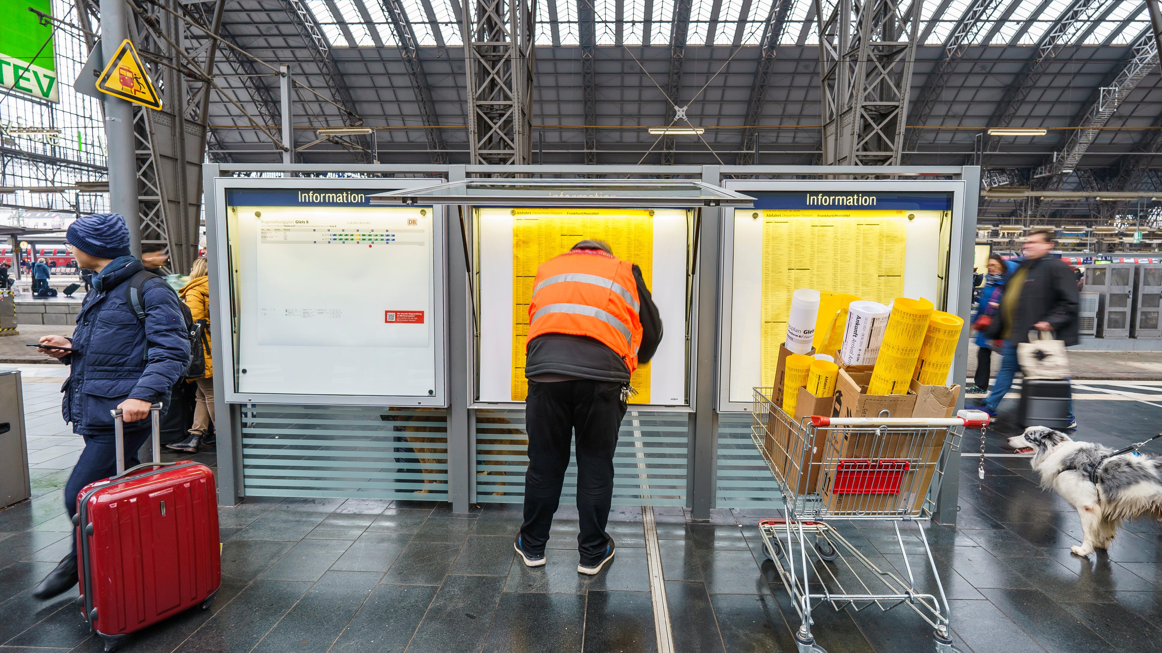 Hessen, Frankfurt/Main: Ein Mitarbeiter vom Bahnhofsmanagement hängt die neuen Fahrpläne in die Infokästen am Hauptbahnhof.