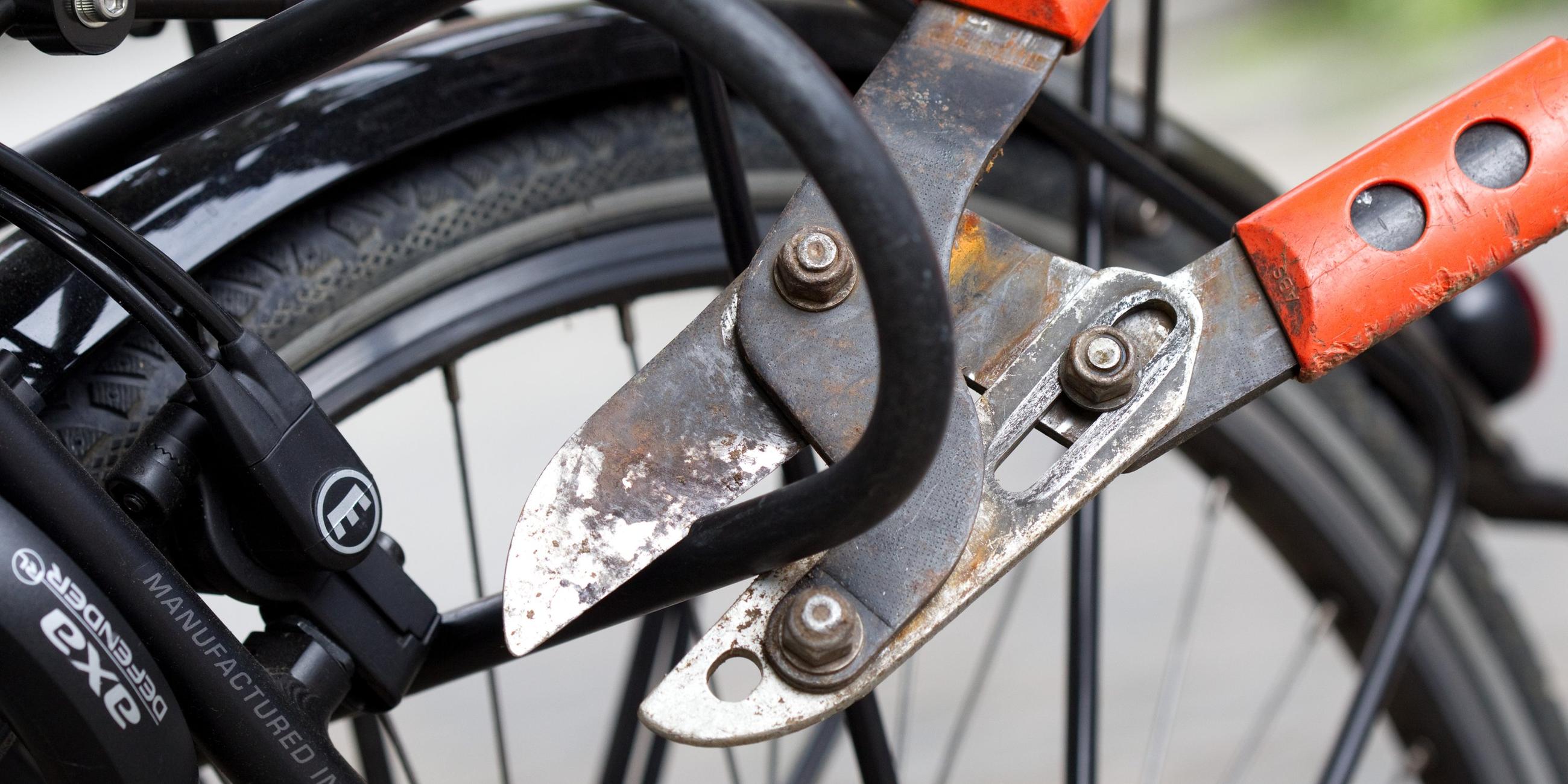 Ein Bolzenschneider wird verwendet, um ein Fahrradschloss aufzubrechen.