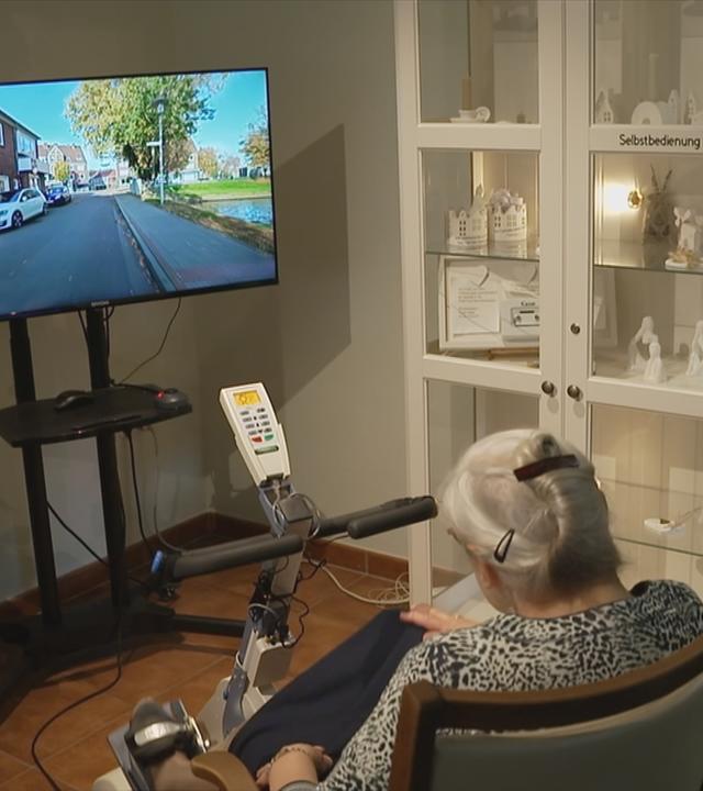 Seniorin simuliert Fahrradfahren durch ihre Heimatstadt.