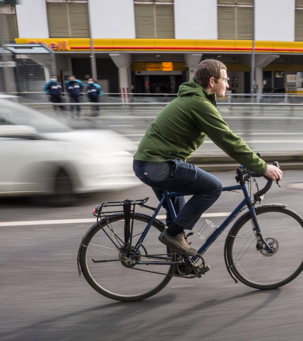 Fahrradfahrer auf Fahrradweg neben Autos,aufgenommen am 02.02.2022 in frankfurt am Main
