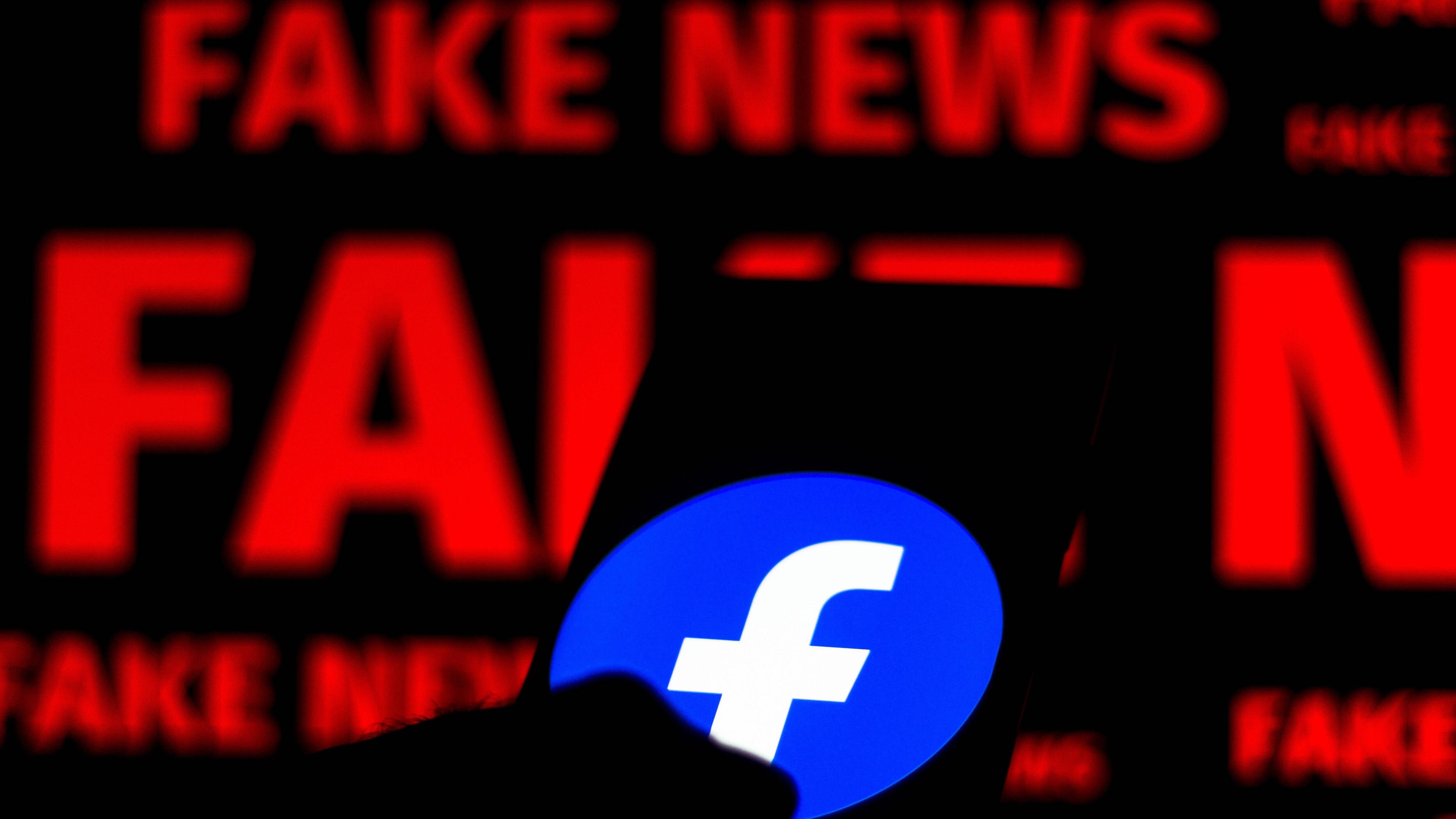 Ein Handy mit Facebook-Logo vor dem Schriftzug Fake News. (Symbolbild)