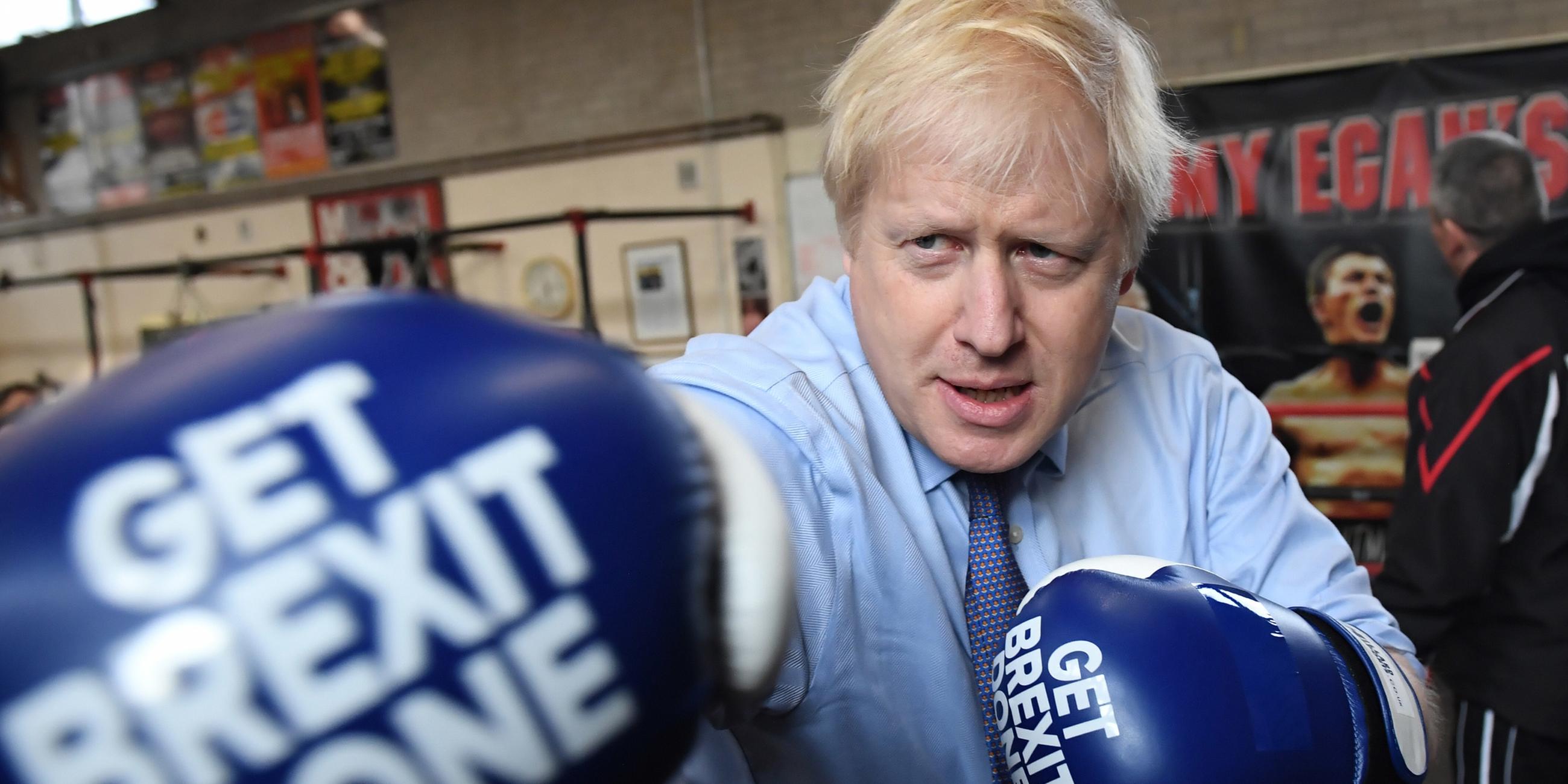 Boris Johnson mit Boxhandschuhen, die den Schriftzug "GET BREXIT DONE" tragen. Er streckt die rechte Faust vor.