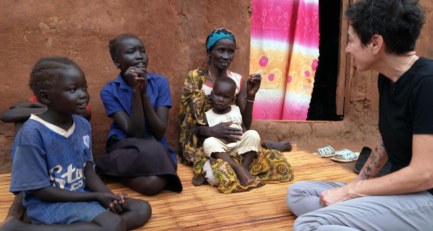 Dunja Hayali mit einer Familie in einem Flüchtlingslager im Südsudan