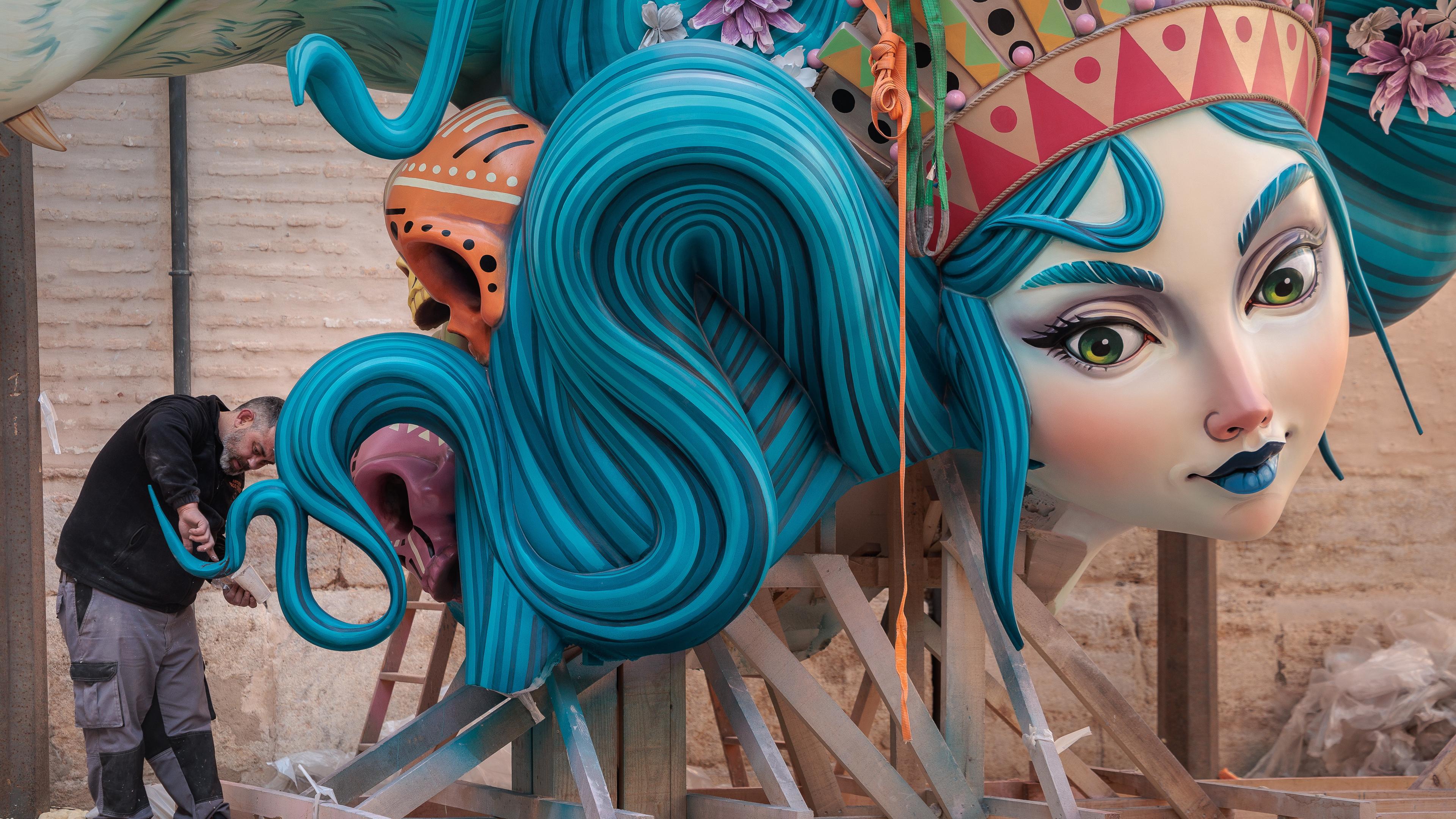 Großes Holzkunstwerk mit Frauengesicht in einer Stadt