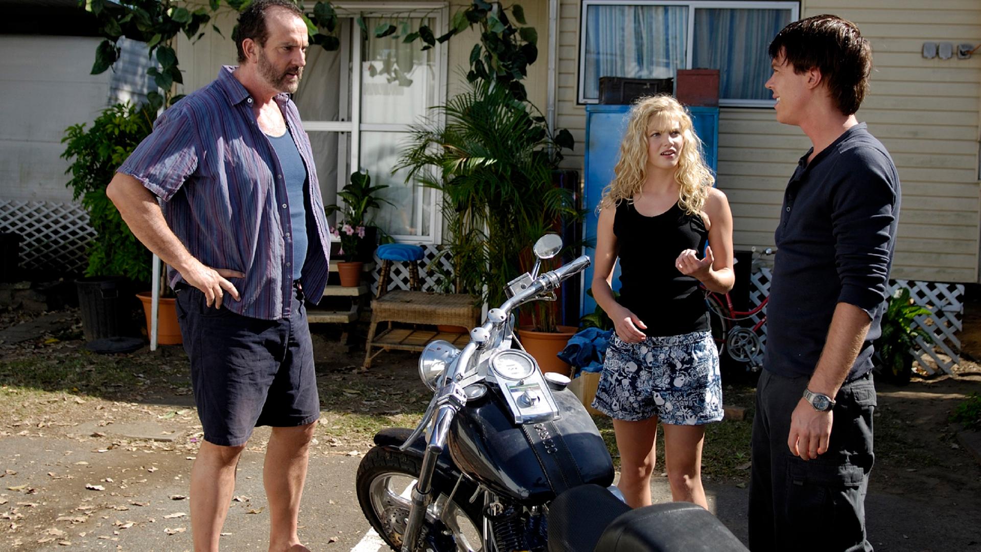 Terry, Rikkis Vater, schimpft mit Nate. Rikki und ein Motorrad stehen zwischen den beiden.