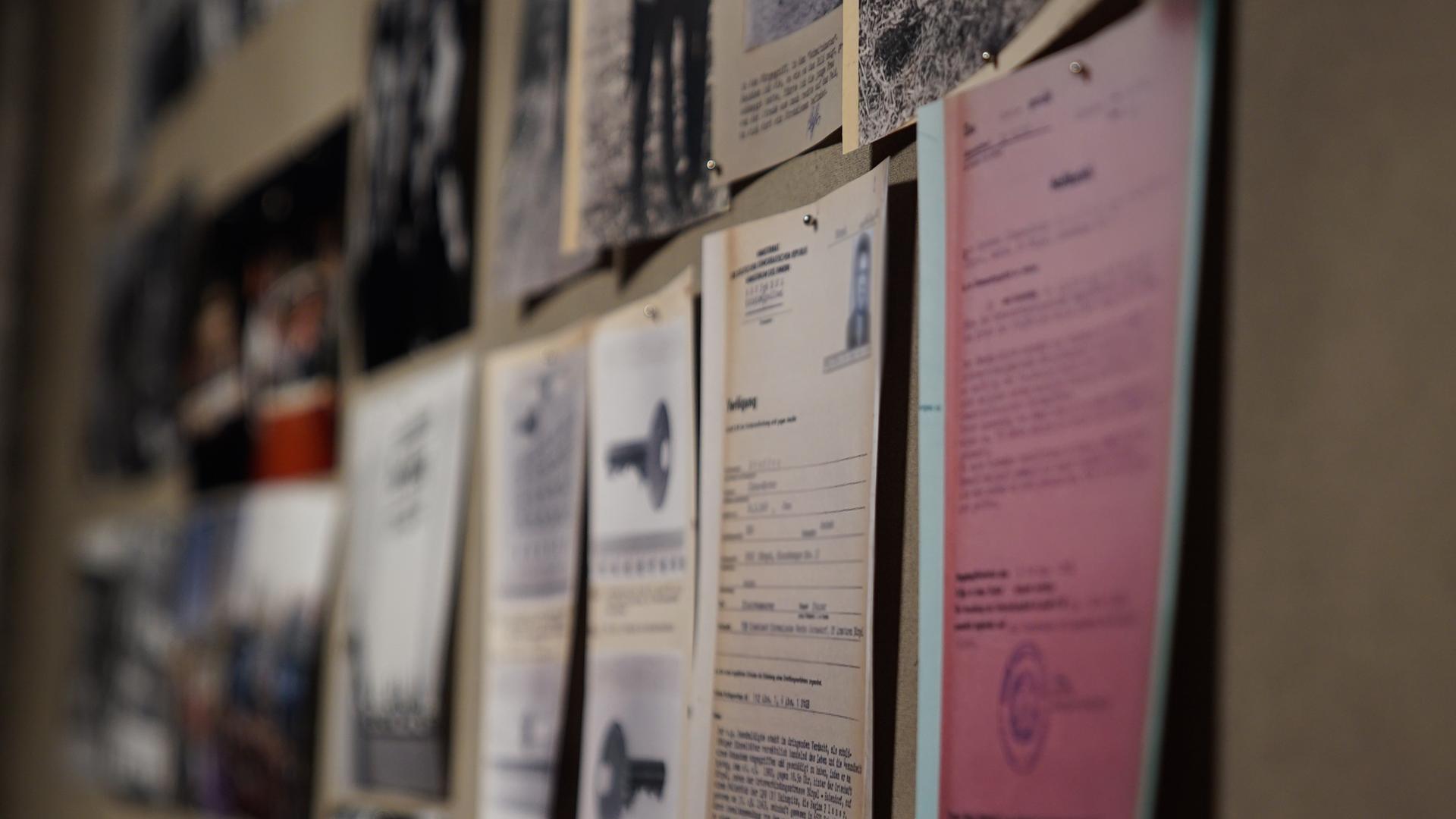 "Falsche Gnade? - Justizversagen in der Wendezeit": An einer Wand hängen unterschiedliche Dokumente und Fotos zu verurteilten Straftätern aus der ehemaligen DDR.