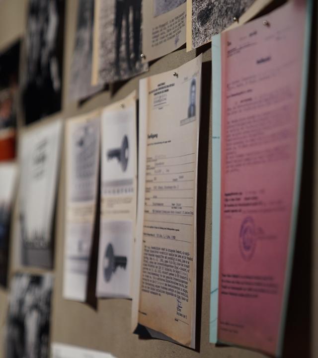 "Falsche Gnade? - Justizversagen in der Wendezeit": An einer Wand hängen unterschiedliche Dokumente und Fotos zu verurteilten Straftätern aus der ehemaligen DDR.
