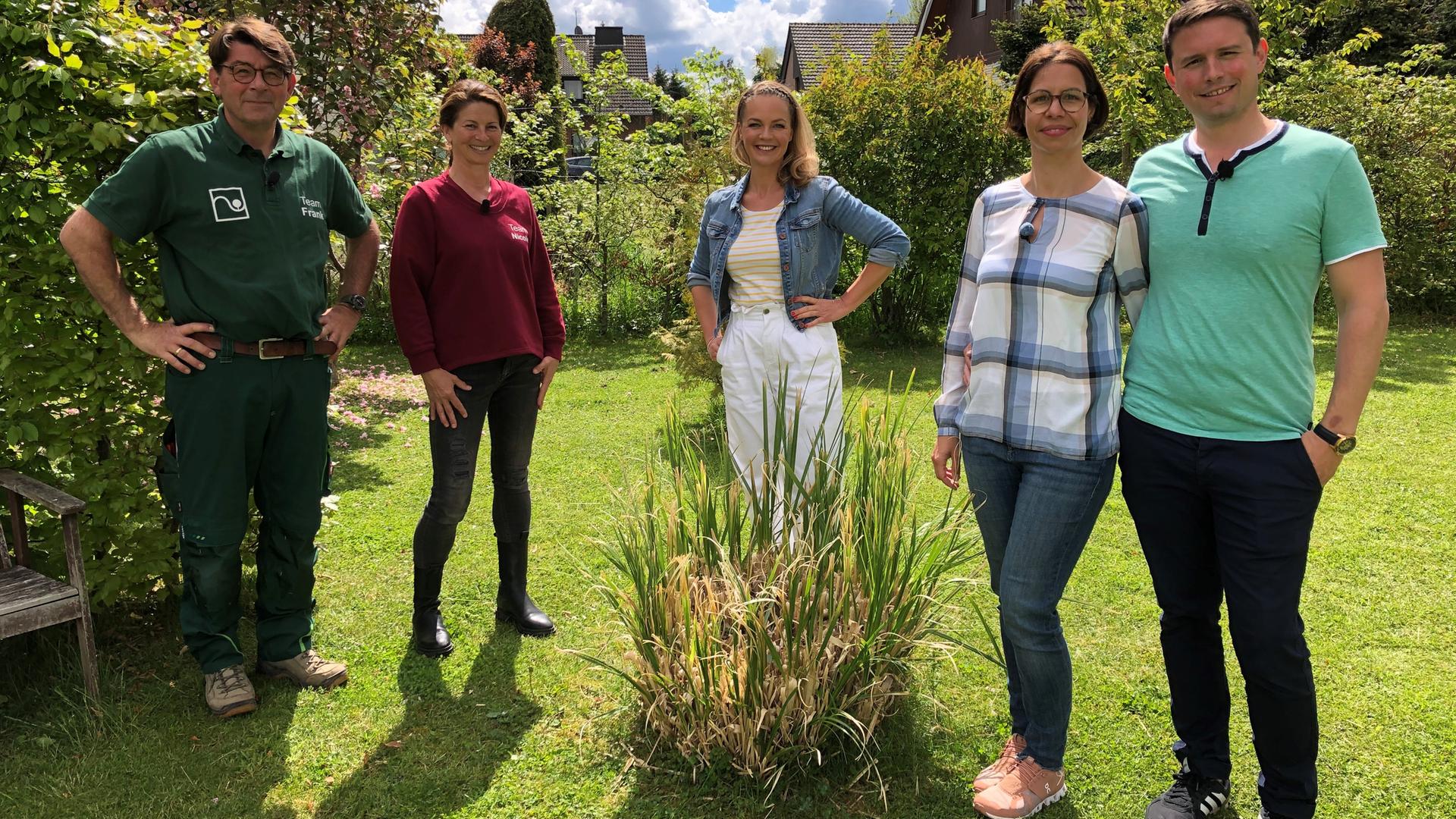 Familie Springhub (rechts) in ihrem Garten, mit Moderatorin Eva Brenner (Mitte) und den Gartenprofis Nicole Johag und Frank Riese (links).