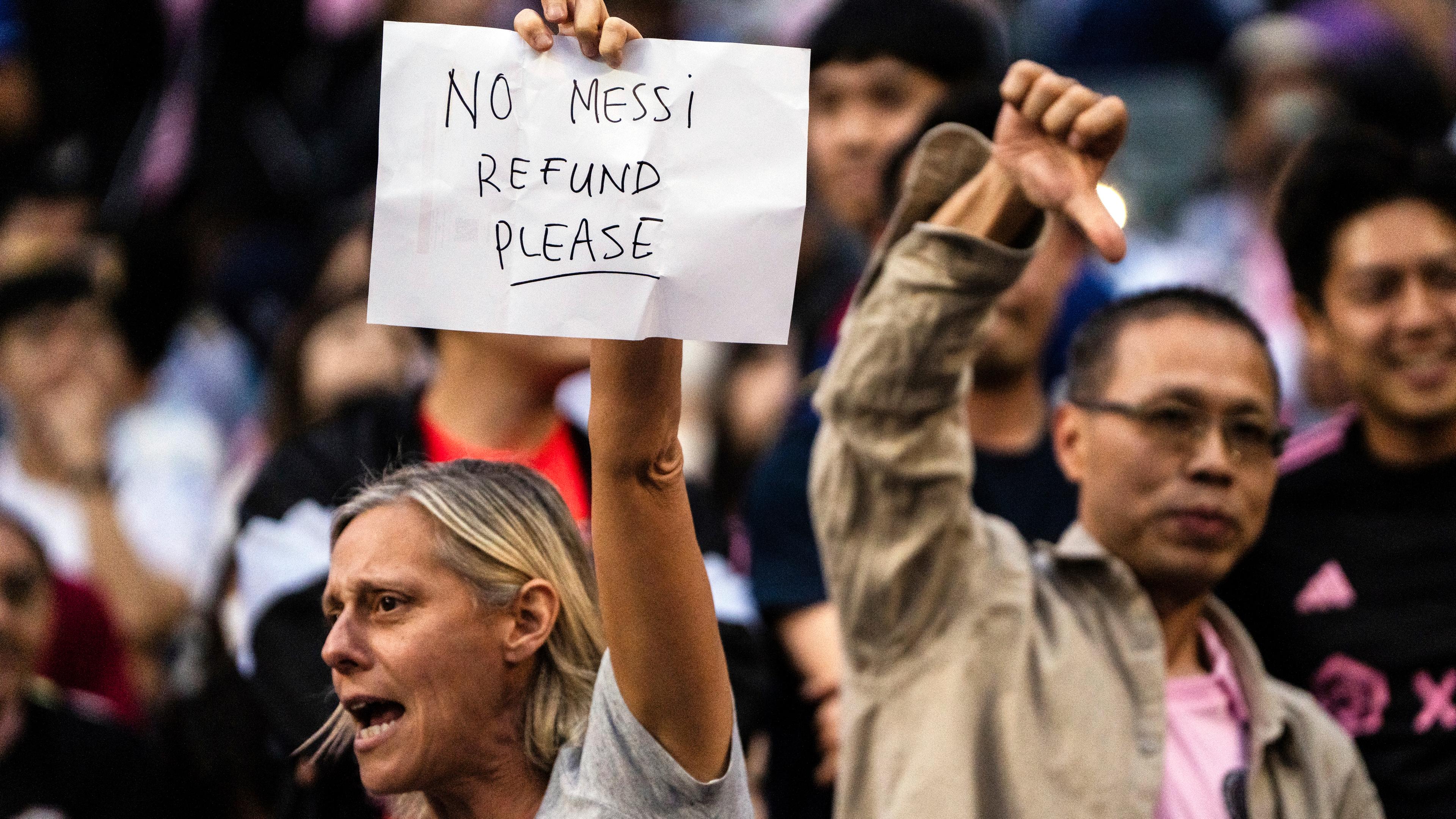 Fans in Hongkong halten ein Schild hoch und zeigen ihr Unverständnis, warum Lionel Messi nur auf der Bank saß