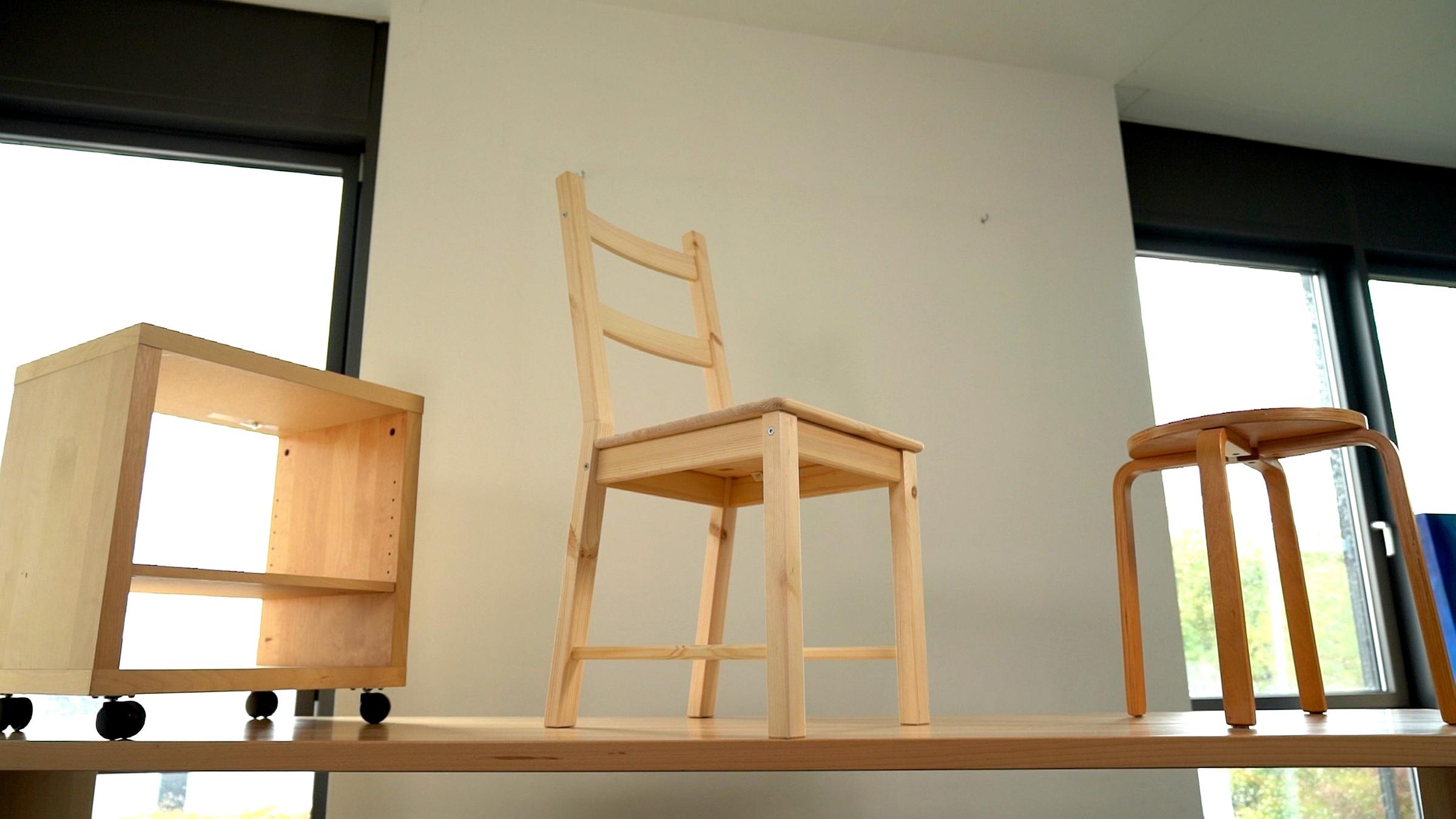 Auf einem Regal stehen mehrere Möbelstücke aus Holz.