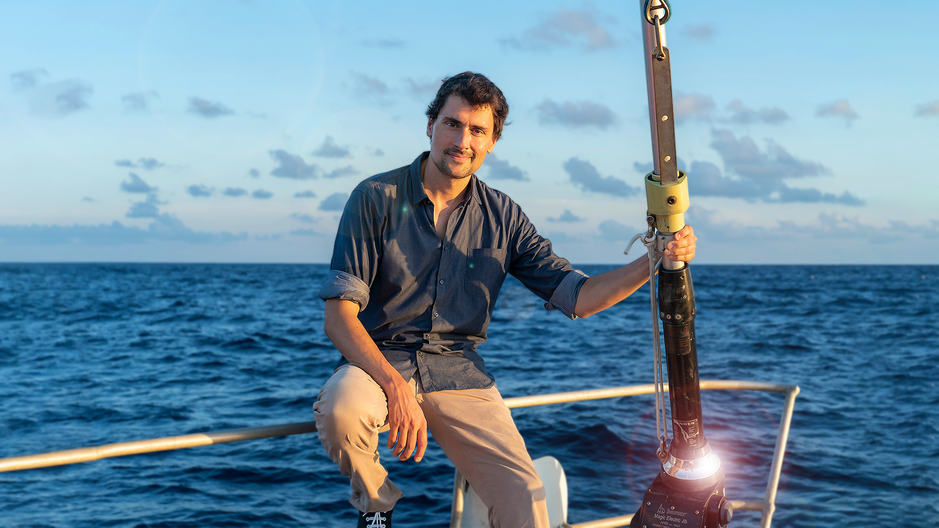 Uli Kunz sitzt an der Spitze eines Schiffes vor dem Meer.