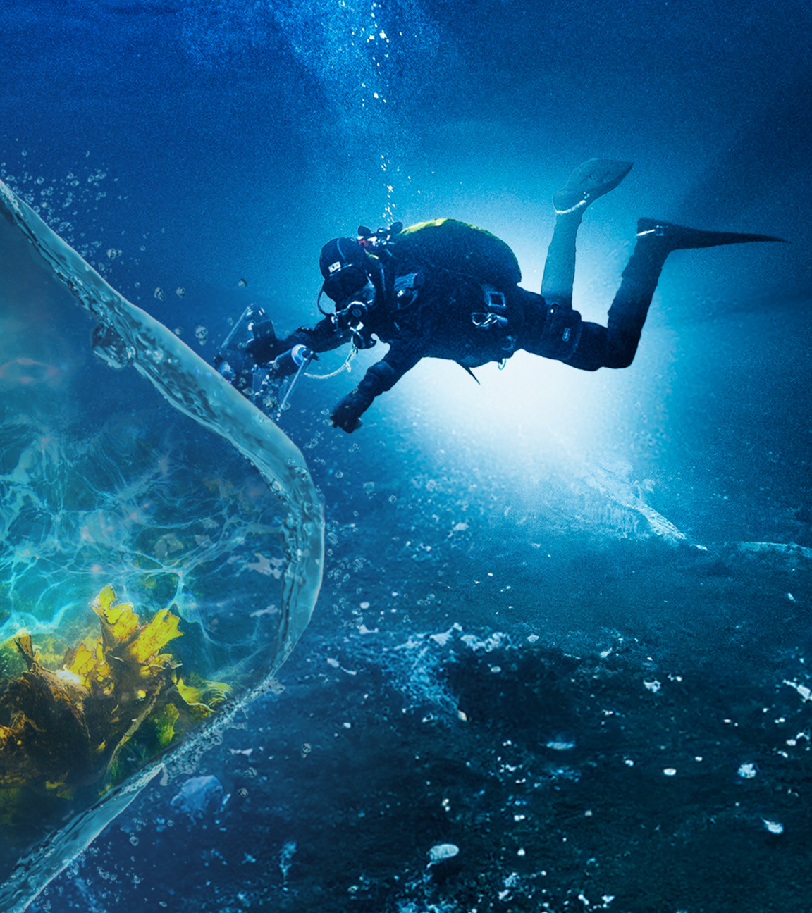 Uli Kunz taucht vor dem Schein einer Lampe im Meer