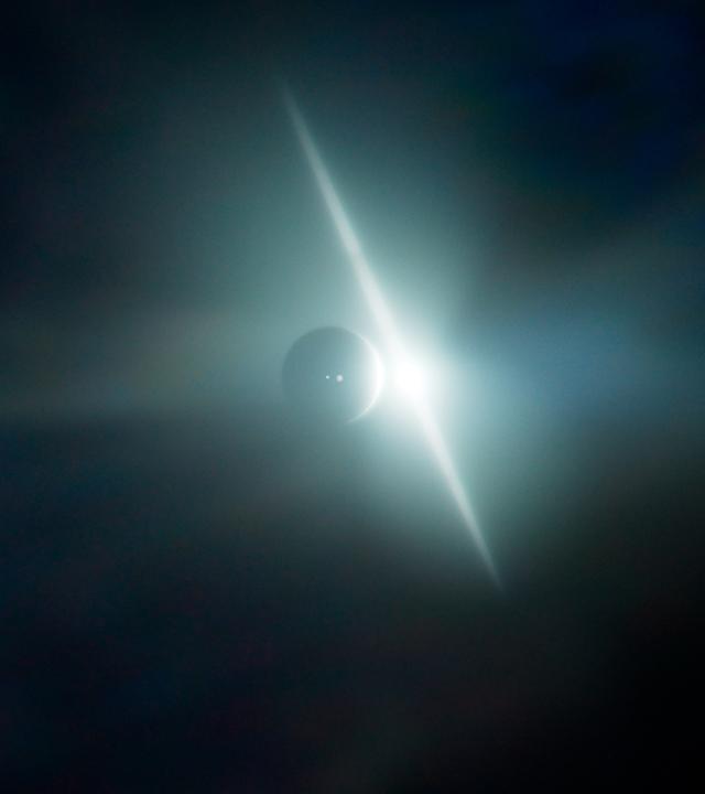 Computeranimation zweier Planeten in unterschiedlicher Entfernung von einem Lichtblitz.