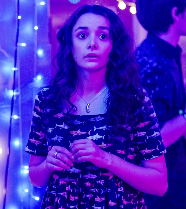 Addie auf der Geburtstagsparty der Zwillinge, um sie herum Lichterketten und links eine aufstellbare Diskokugel.