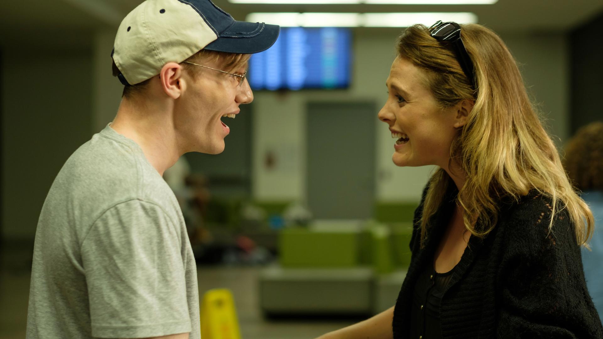 "Fatale Zusammentreffen: Die Hoffnung stirbt zuletzt": Nachgestellte Szene: Ein Mann und eine Frau an einem Flughafen-Terminal begrüßen sich erfreut.