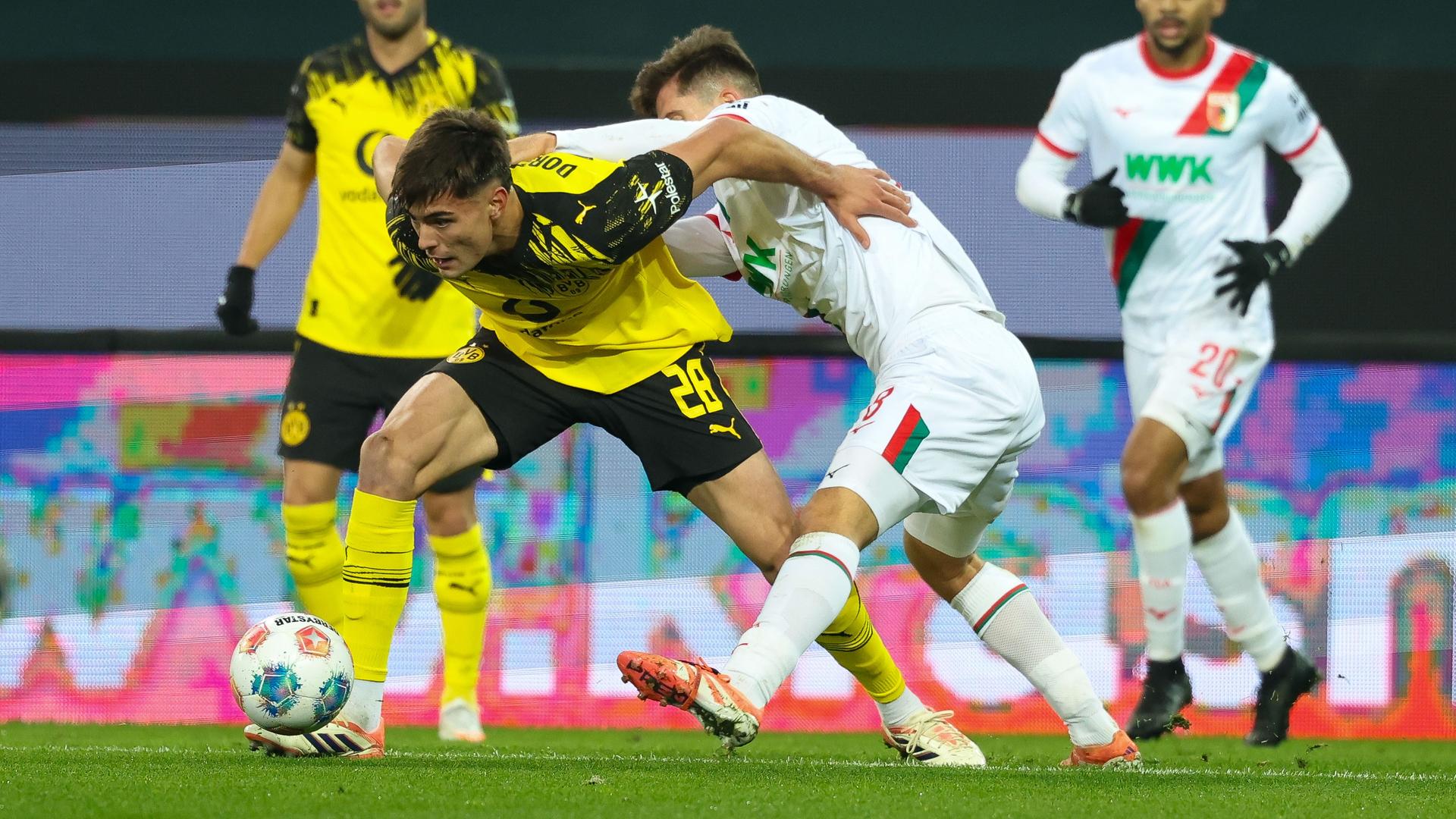 Im Zweikampf: Anselmino von Borussia Dortmund gegen Elvis Rexhbecaj (FC Augsburg)