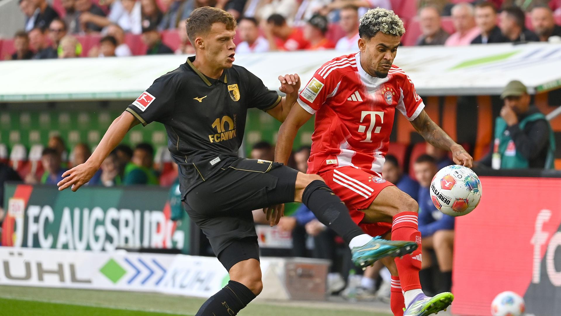 Die Spieler von FC Augsburg und FC Bayern München kämpfen.