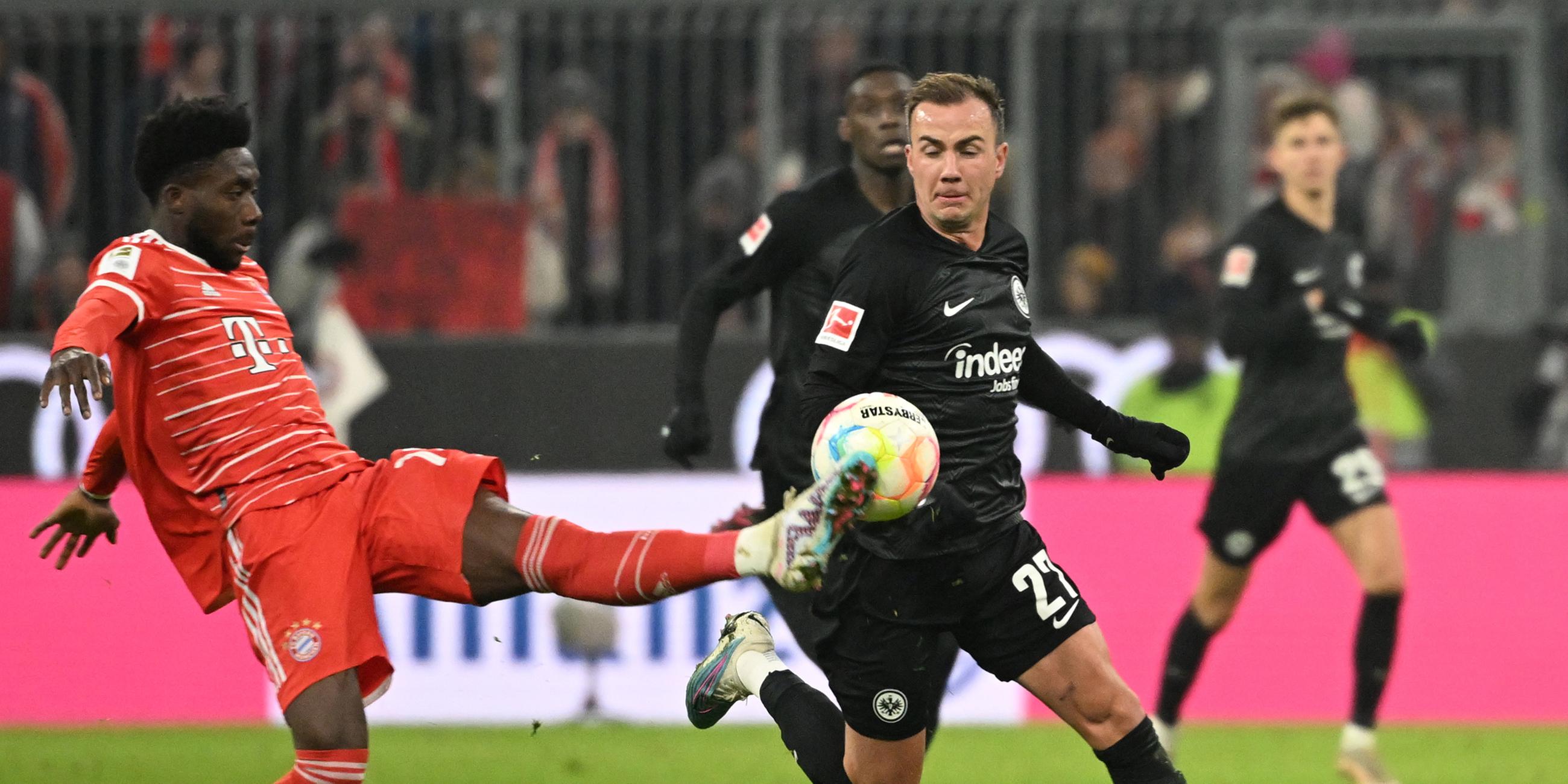 Münchens Alphonso Davies (l) und Frankfurts Mario Götze kämpfen um den Ball.