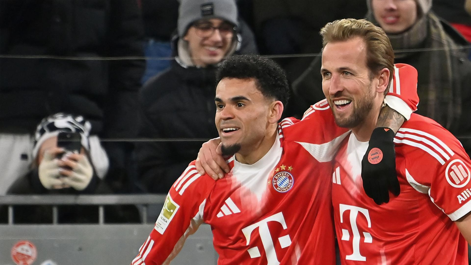 Bundesliga: FC Bayern - VfL Wolfsburg: Luis Diaz und Harry Kane jubeln Arm in Arm.