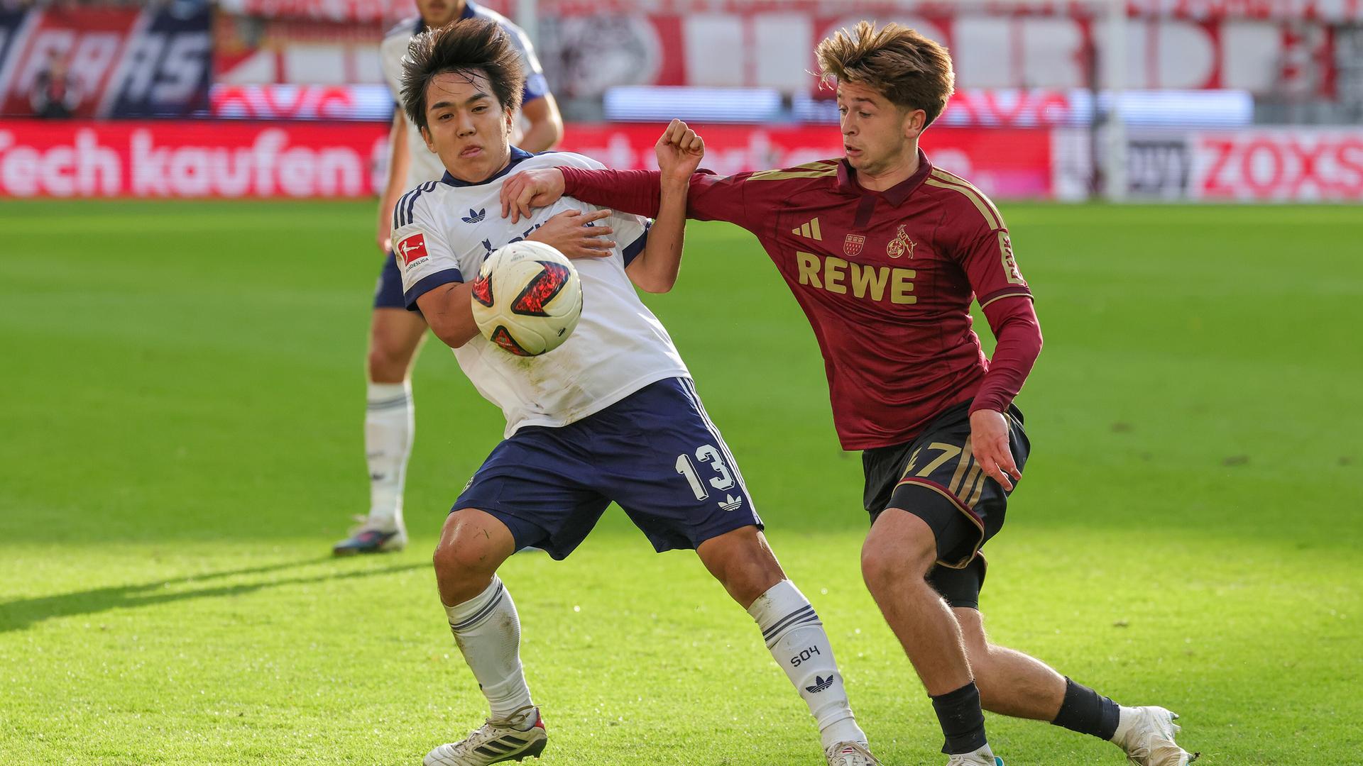 Satoshi Tanaka (FC Schalke 04) und Mikey Moore (1.FC Köln) kämpfen. 