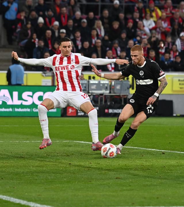 Saïd El Mala (1. FC Köln) und Torwart Nikola Vasilj (FC St. Pauli) kämpfen. 