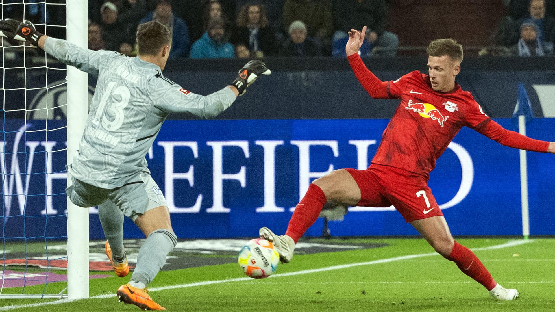 Schalkes Schalkes Torhüter Alexander Schwolow und Dani Olmo von Leipzig versuchen an den Ball zu kommen.