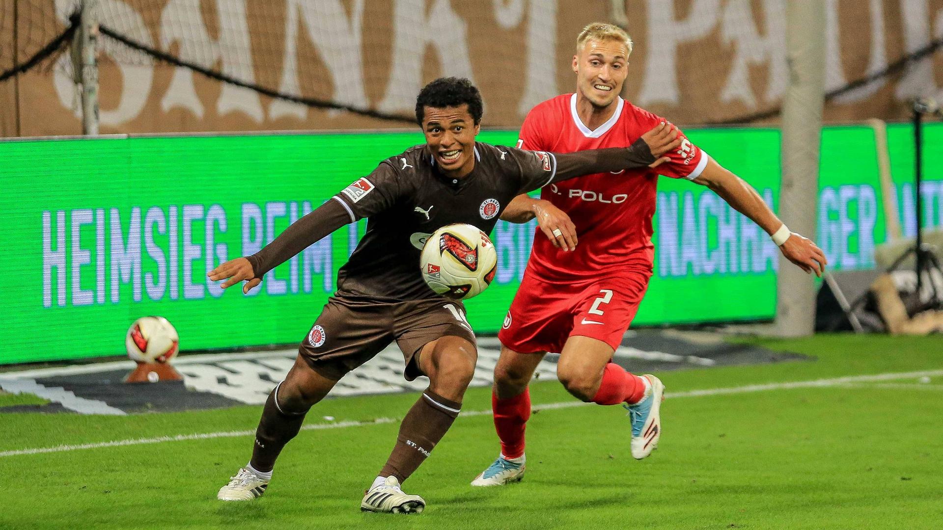 Wolfsburgs Verteidiger Kilian Fischer bedrängt seinen Gegenspieler Joel Chima Fujita im Zweikampf von hinten