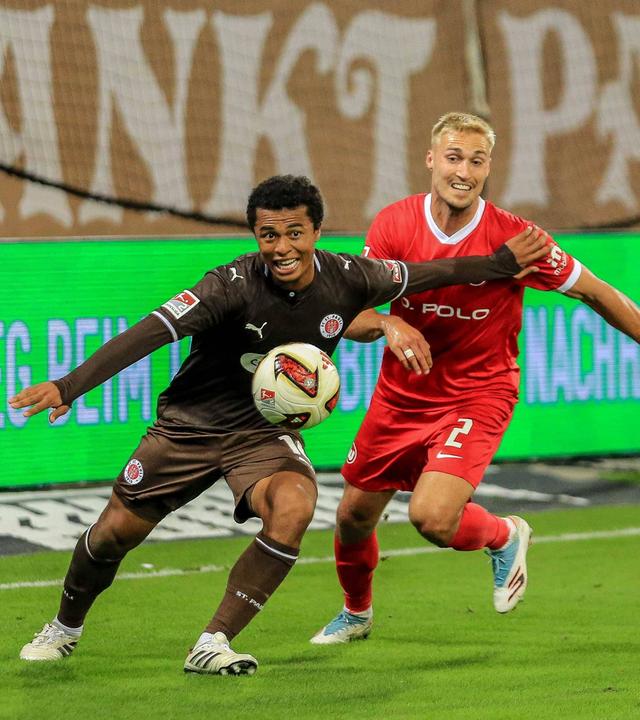 Wolfsburgs Verteidiger Kilian Fischer bedrängt seinen Gegenspieler Joel Chima Fujita im Zweikampf von hinten