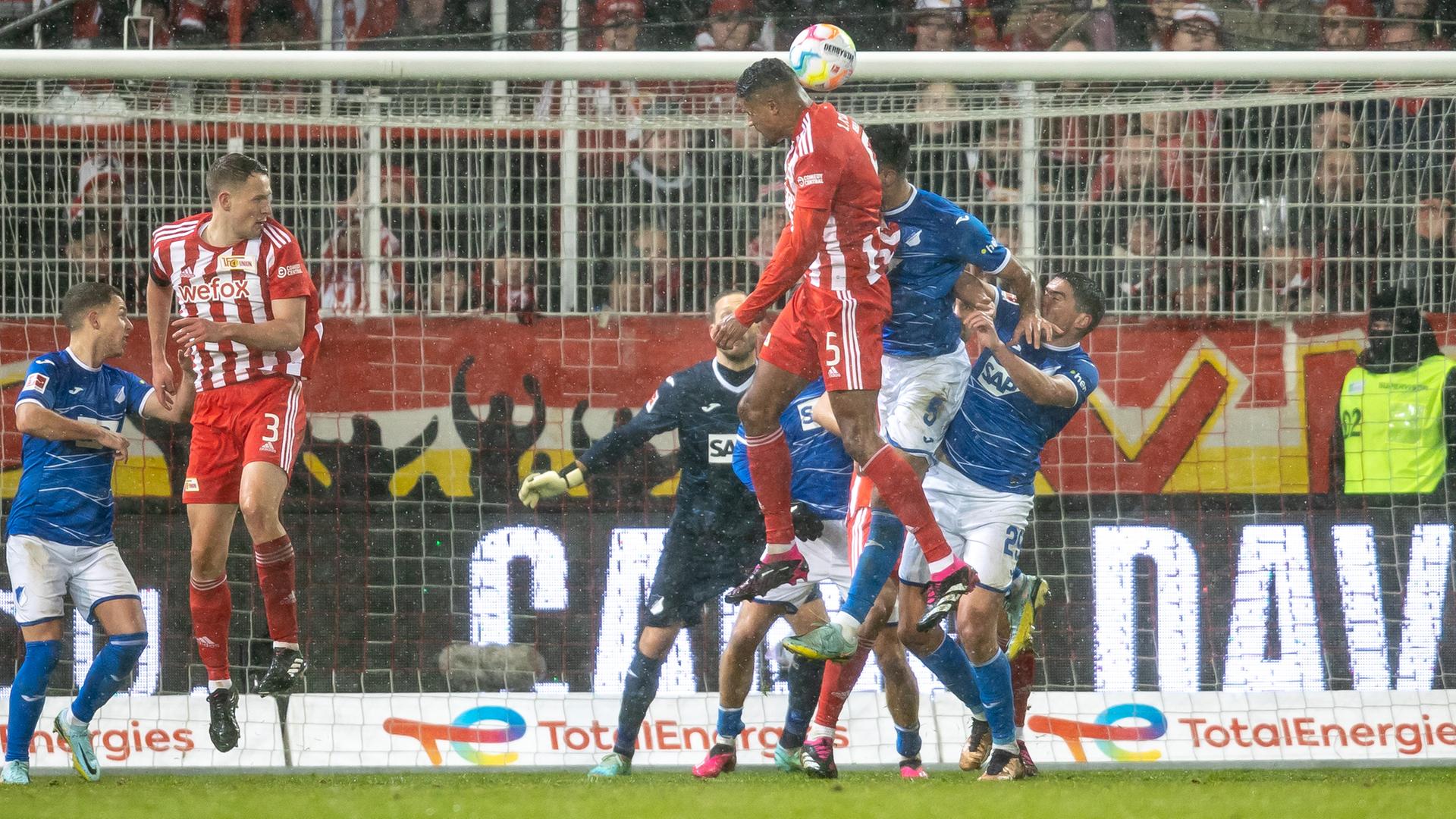 21.01.2023, Berlin: Fußball: Bundesliga, 1. FC Union Berlin - TSG 1899 Hoffenheim, 16. Spieltag, An der Alten Försterei. Berlins Danilho Doekhi (3.v.r) geht zum Kopfball gegen Ozan Kabak (2.v.r) von TSG Hoffenheim.