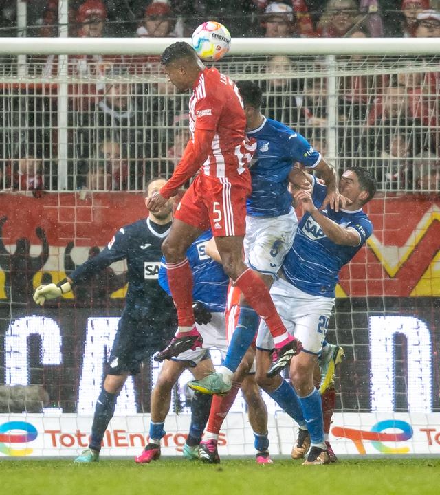21.01.2023, Berlin: Fußball: Bundesliga, 1. FC Union Berlin - TSG 1899 Hoffenheim, 16. Spieltag, An der Alten Försterei. Berlins Danilho Doekhi (3.v.r) geht zum Kopfball gegen Ozan Kabak (2.v.r) von TSG Hoffenheim.