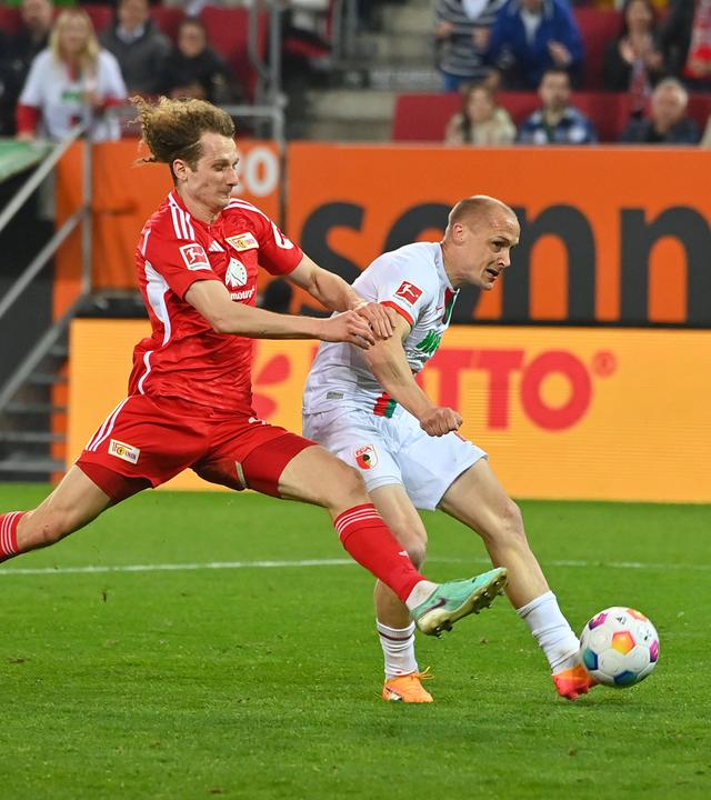 Sven Michel (FC Augsburg) trifft im Bundesliga-Spiel gegen Union Berlin am 12.4.2024 zum 2:0. Links Alex Kral (Union Berlin)