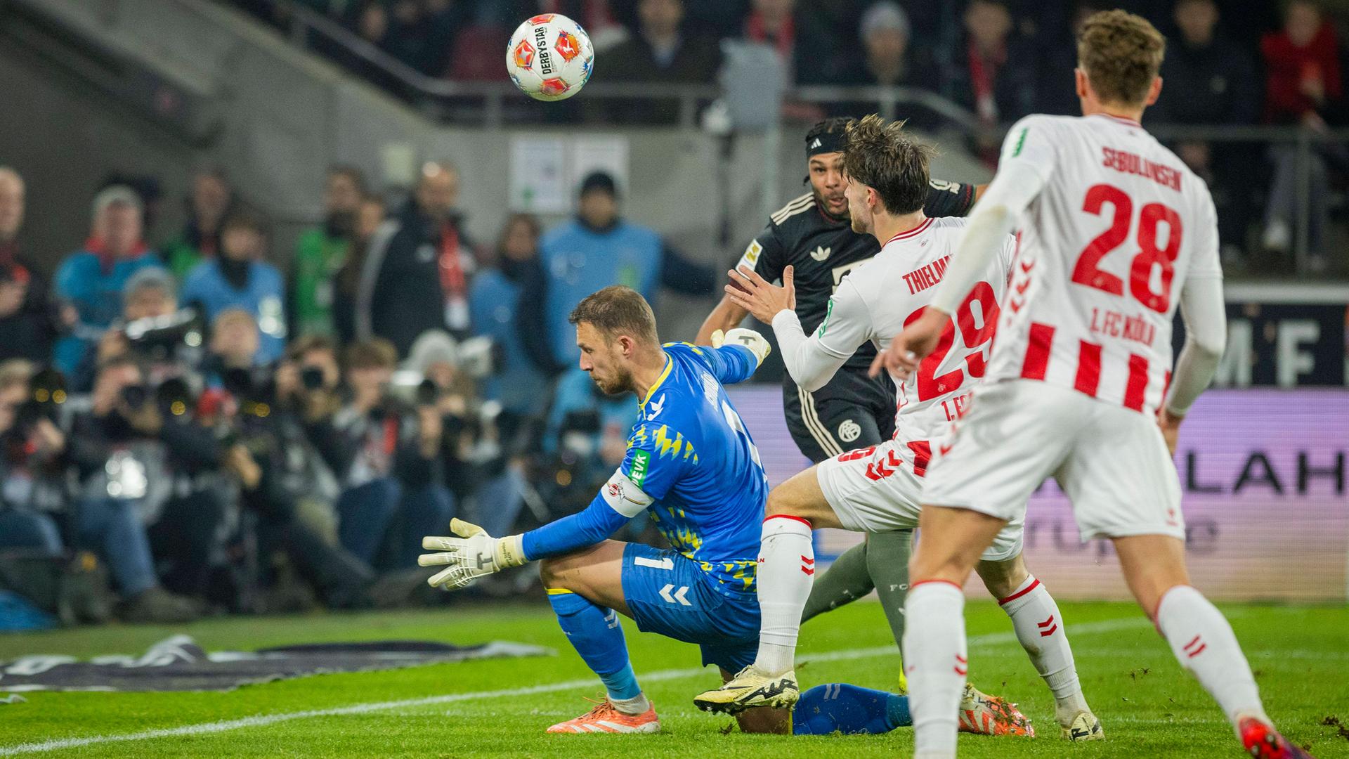 Serge Gnabry (FC Bayern) erzielt den Ausgleich zum 1:1 gegen Marvin Schwäbe (1. FC Köln), während Jan Thielmann (1. FC Köln) beteiligt ist. 1. FC Köln – Bayern München.