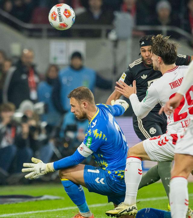 Serge Gnabry (FC Bayern) erzielt den Ausgleich zum 1:1 gegen Marvin Schwäbe (1. FC Köln), während Jan Thielmann (1. FC Köln) beteiligt ist. 1. FC Köln – Bayern München.